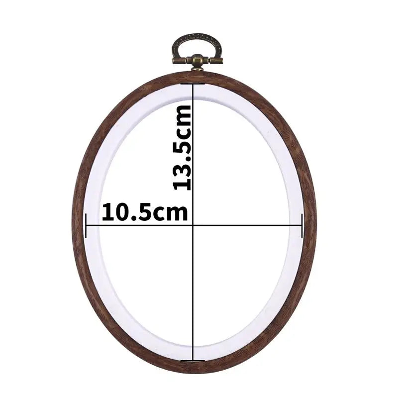 A round wooden embroidery hoop with a clear plastic cover and a metal hook for cross-stitch and needlework.