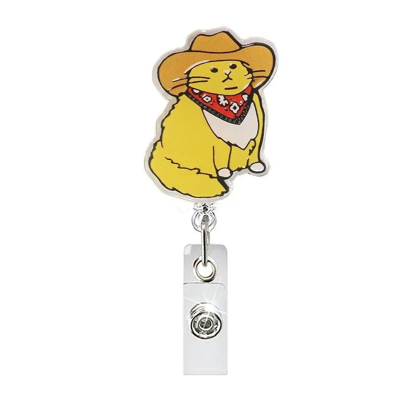 A yellow cat charm with a red collar is attached to a glitter acrylic badge reel.