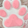 A white silicone squeeze toy shaped like a cat paw in various shades of pink for stress relief and fidgeting.