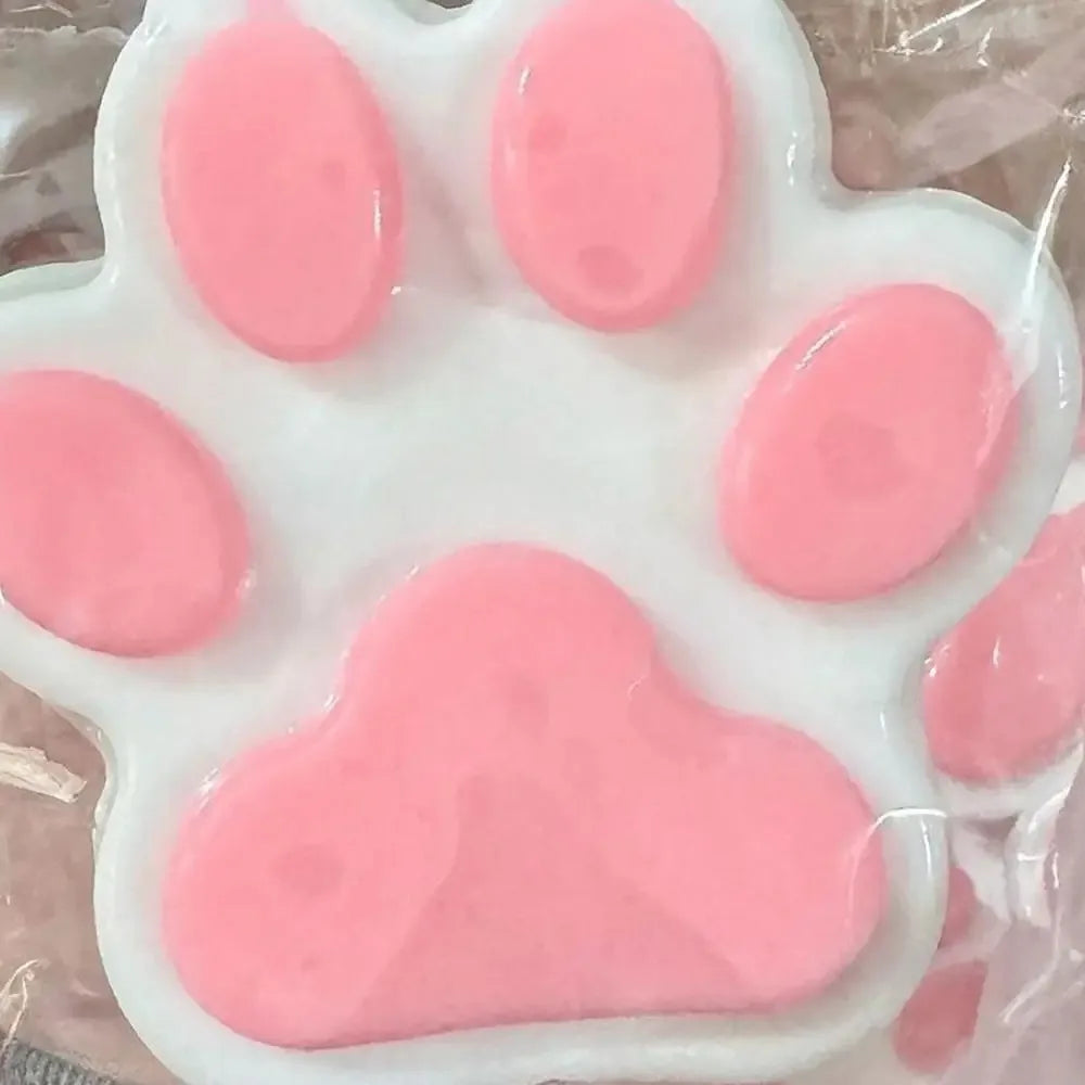 A white silicone squeeze toy shaped like a cat paw in various shades of pink for stress relief and fidgeting.