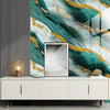 A modern interior featuring a marble-patterned accent wall with teal and gold veining, above a white cabinet.