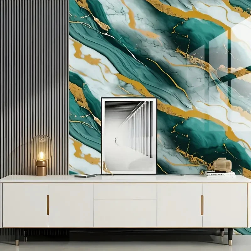 A modern interior featuring a marble-patterned accent wall with teal and gold veining, above a white cabinet.