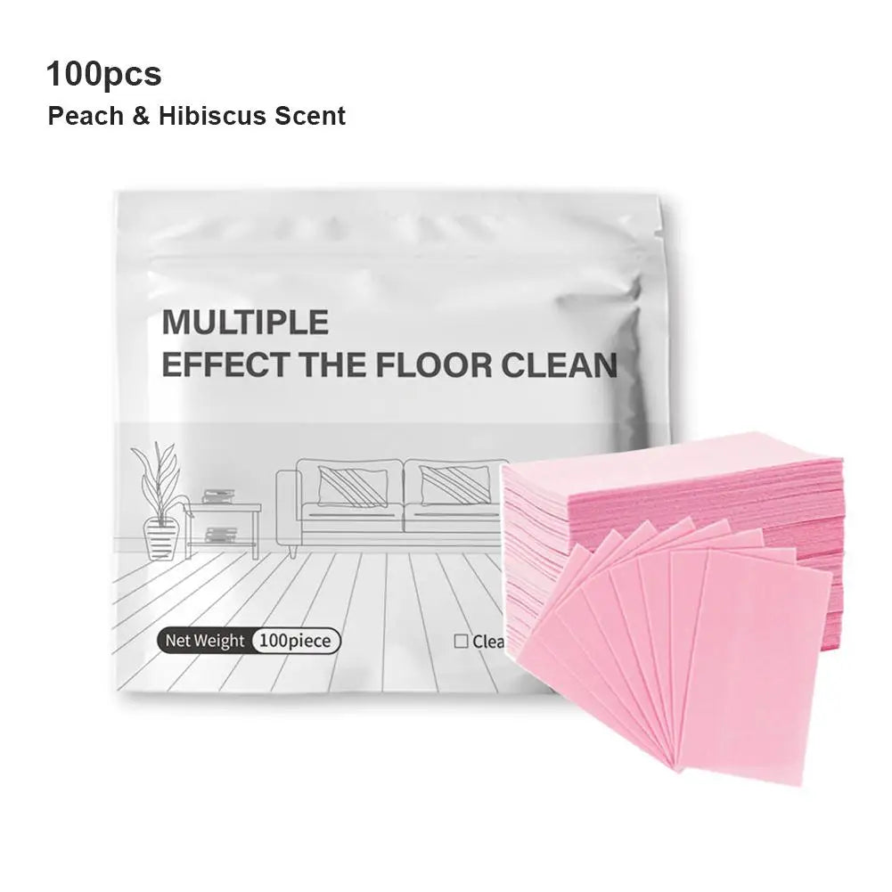 A package of 100 peach and hibiscus scented floor cleaning tablets with pink sheets displayed next to a wooden floor.