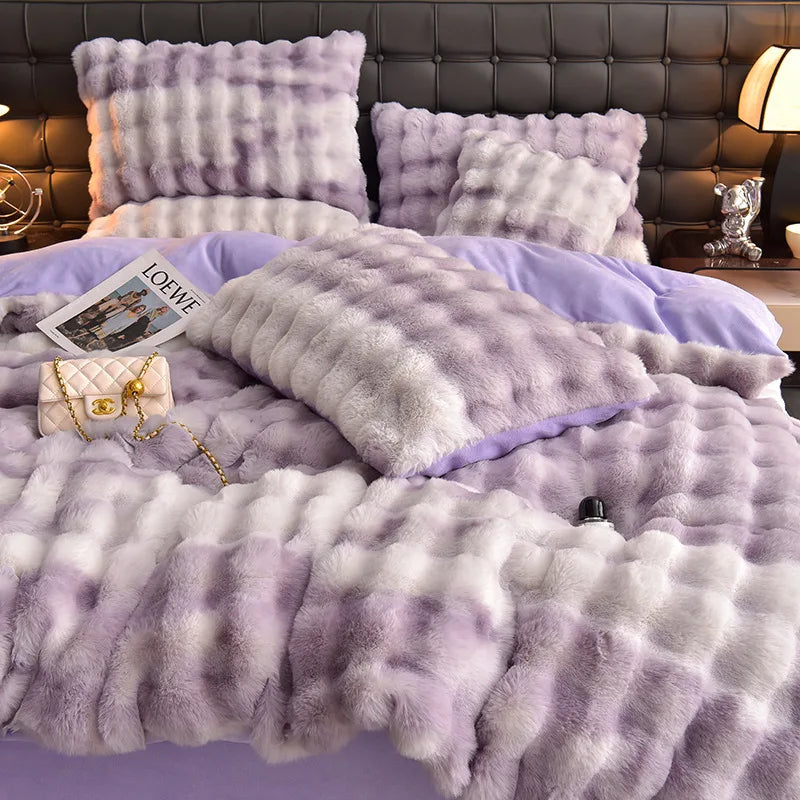 A fluffy lavender and white quilted bedding set featuring pillows and a duvet on a bed.