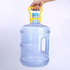 A hand is holding a clear blue water bucket with a yellow handle and a blue cap.