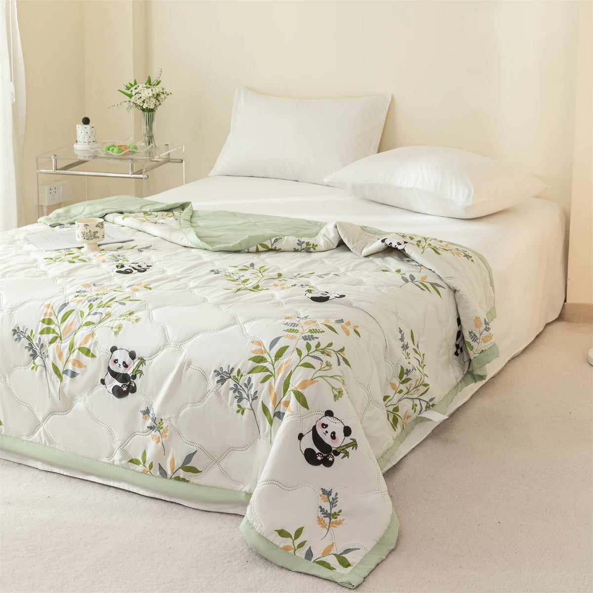 White quilted summer quilt featuring a pattern of pandas and green foliage on a bed.
