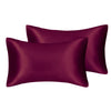A set of two deep plum satin pillowcases for hair and skin.