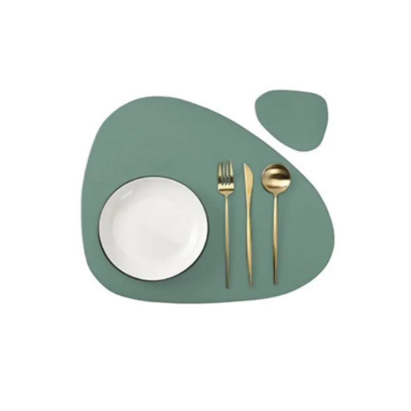 A set of gold-toned cutlery resting on a light green placemat.
