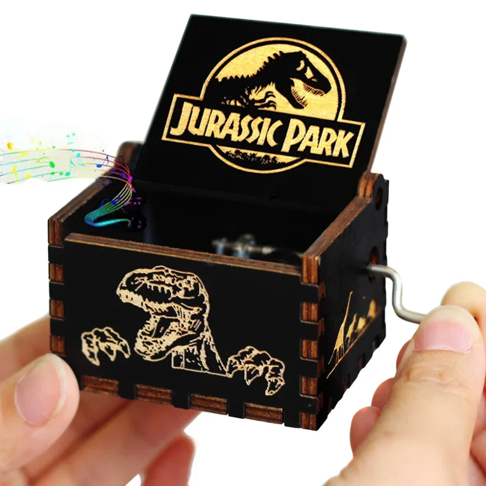 A hand holding a vintage hand-crank wooden music box with a Jurassic Park theme and an open lid.