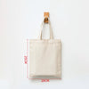 A beige canvas shopping tote bag with a wooden handle, shown against a white background.