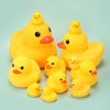 A pile of small, bright yellow rubber duck toys for babies.