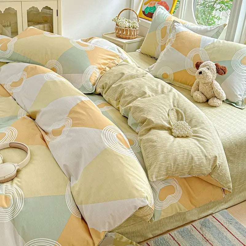 A set of light yellow and sage green cotton duvet covers and pillow shams with decorative stitching.