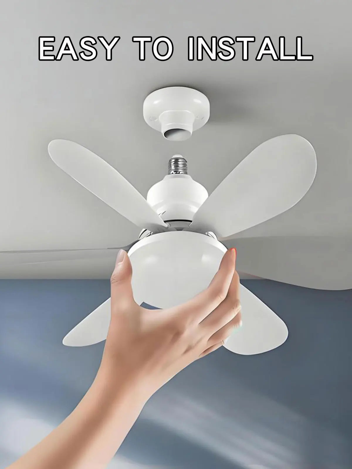 A hand is installing a white remote-controlled ceiling fan with a light fixture onto a ceiling.