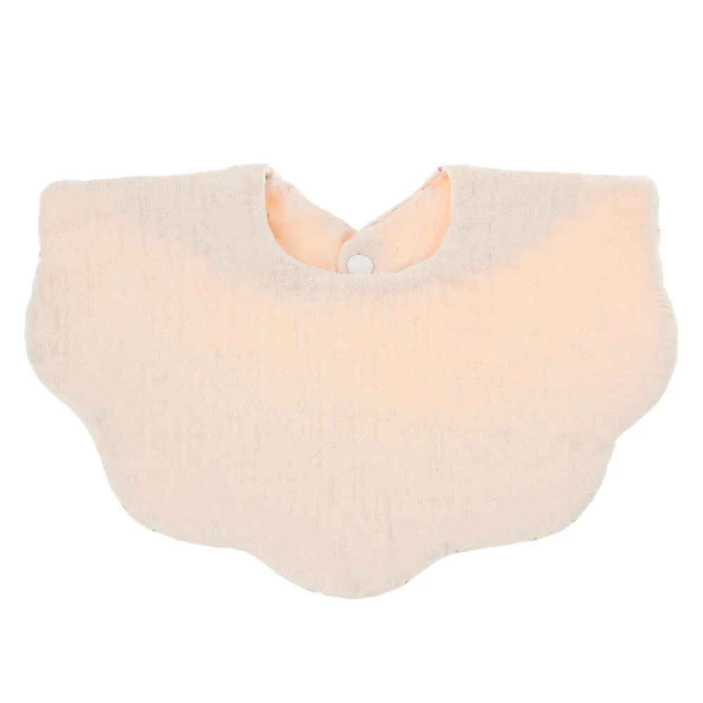 A light peach colored soft cotton baby bib in a bandana style for newborns.