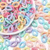 A pile of colorful acrylic jewelry connector clasps with crystal accents in various shades of pink, purple, blue, and yellow.