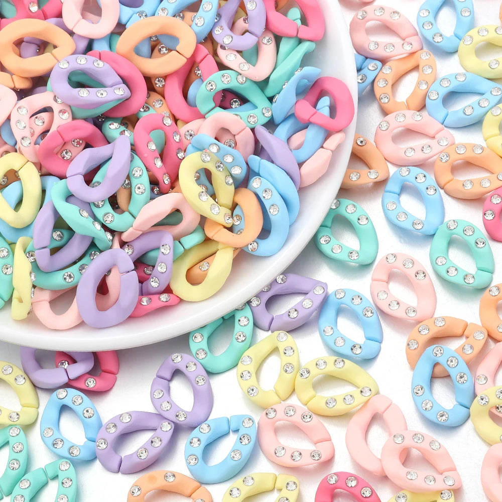 A pile of colorful acrylic jewelry connector clasps with crystal accents in various shades of pink, purple, blue, and yellow.