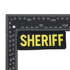 A black embroidered patch with the word SHERIFF in yellow text against a ruler scale.