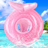 A pink inflatable swim ring is splashing water in clear blue tropical ocean water under a bright sky.