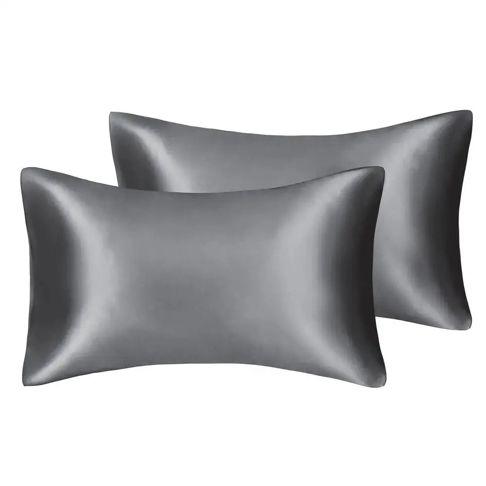 A set of two smooth, dark gray silky satin pillowcases.