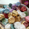 A collection of six-pack silicone molds shaped like roses in various colors including gold, purple, pink, and green.