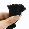 A hand holds a bundle of black natural twisted cotton cord fibers.