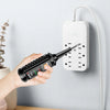 A hand holds an induction test pen with an NCV voltage detector and breakpoint finder against a white wall socket.