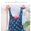 A person holds up a dark blue reusable shopping bag with green stars, demonstrating its strong and durable bearing capacity.