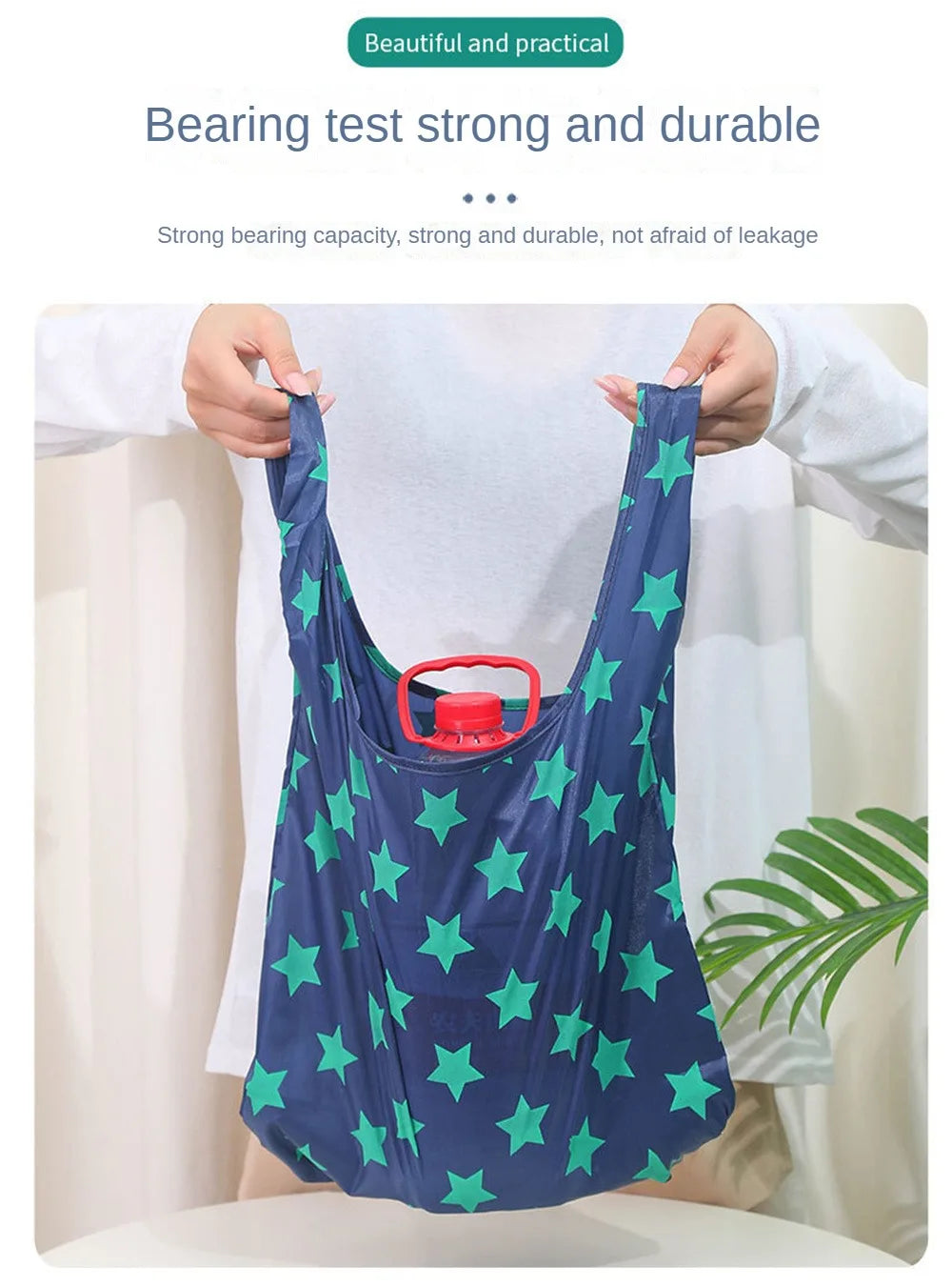 A person holds up a dark blue reusable shopping bag with green stars, demonstrating its strong and durable bearing capacity.