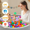 A woman is pouring colorful, non-toxic ball pit balls into a large gray tub, with safety certifications displayed.