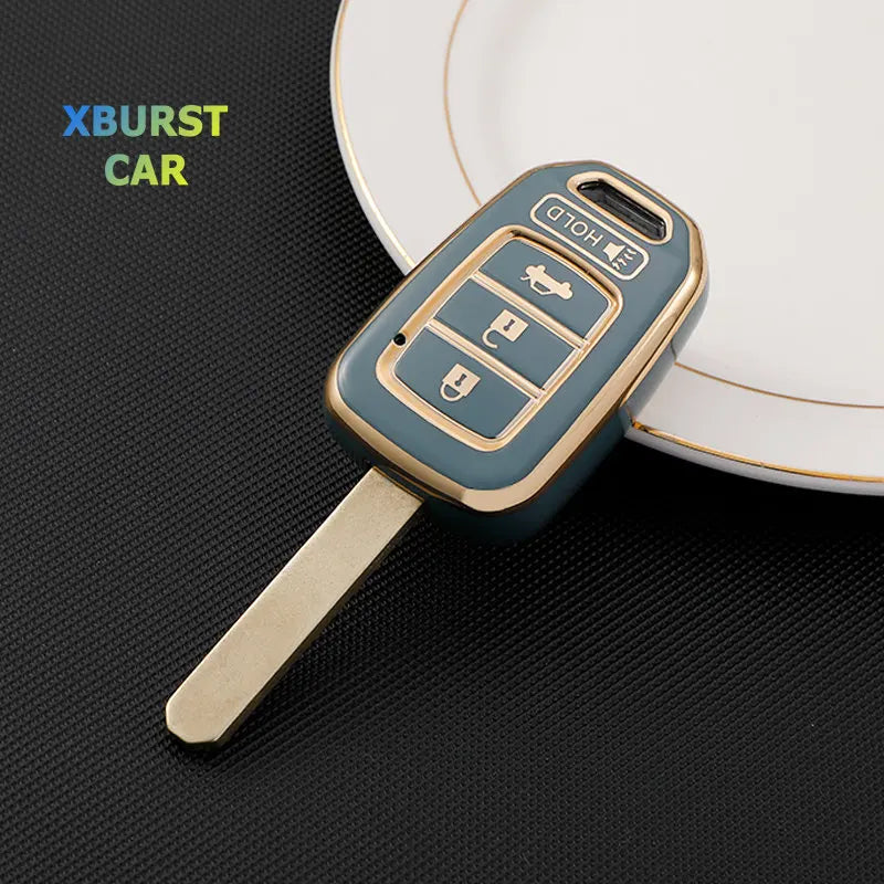 A teal key fob cover with three buttons is shown resting on a white plate.