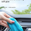 A hand is squeezing a bright blue multi-functional cleaning soft glue gel for car cleaning.