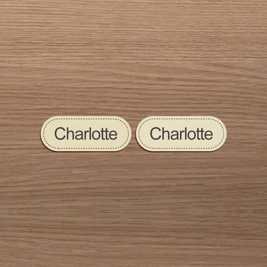 Dos etiquetas ovaladas beige con el nombre Charlotte impreso.