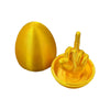 A golden, egg-shaped desk decor featuring a hand making the middle finger gesture.
