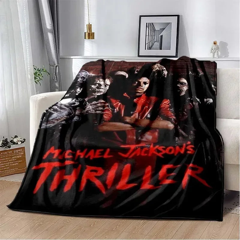A dark flannel throw blanket featuring a red and black graphic of Michael Jackson's thriller title.