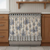 A beige floral oven skirt with a striped ruffle trim installed on a stainless steel oven.