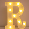 A glowing yellow LED letter night light shaped like the letter R, used for home and party decor.
