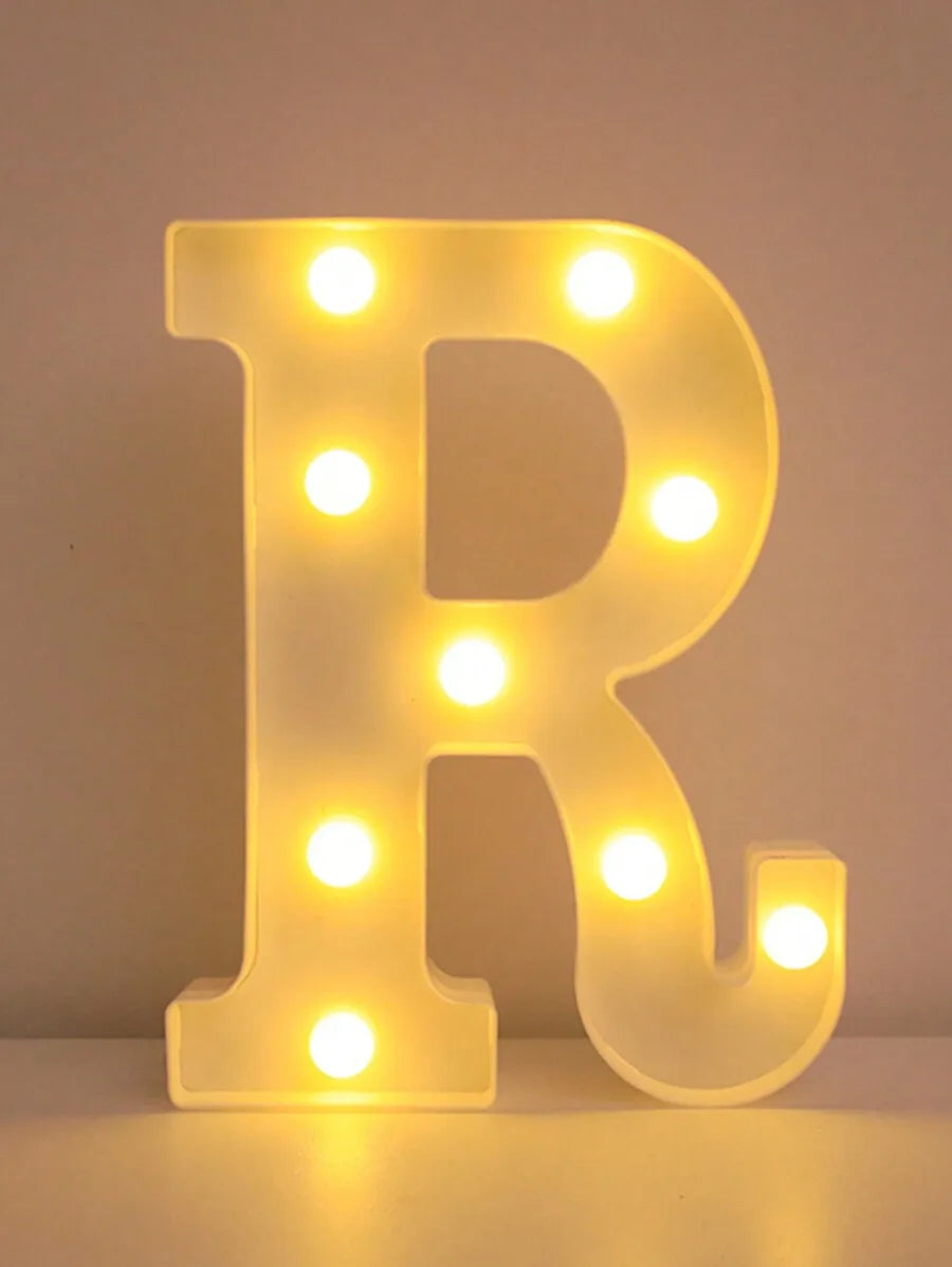A glowing yellow LED letter night light shaped like the letter R, used for home and party decor.