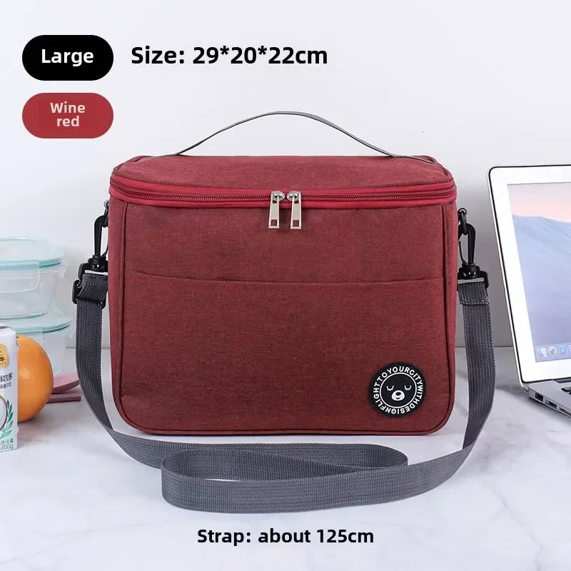 A maroon insulated lunch bag with a gray shoulder strap is shown on a white surface.