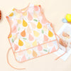 A pink and yellow patterned waterproof baby feeding bib with a sleeveless design featuring fruit shapes.