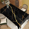 Black gold marble waterproof tablecloth displayed on a wooden table with a green chair and white rug.