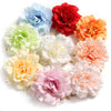 A collection of colorful silk peony flower heads in shades of blue, red, orange, yellow, and pink.