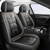 Interior view of a black car seat with gray stitching and leather upholstery.