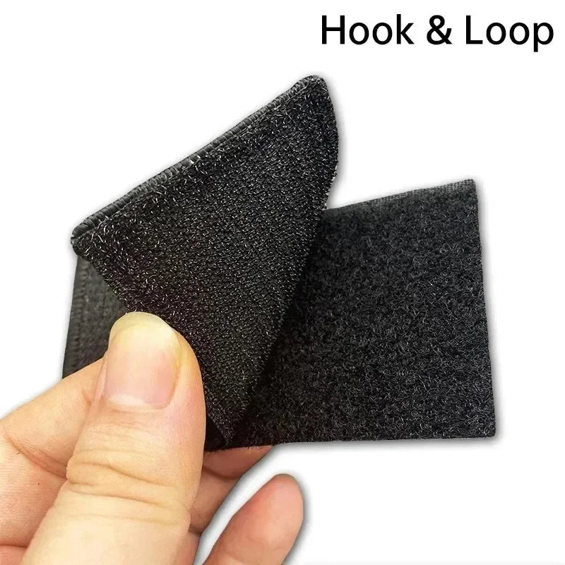 A hand holds a black Hook & Loop patch for bags and gear