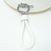 Silver key fob cover with a white braided cord attached, resting on a white surface.