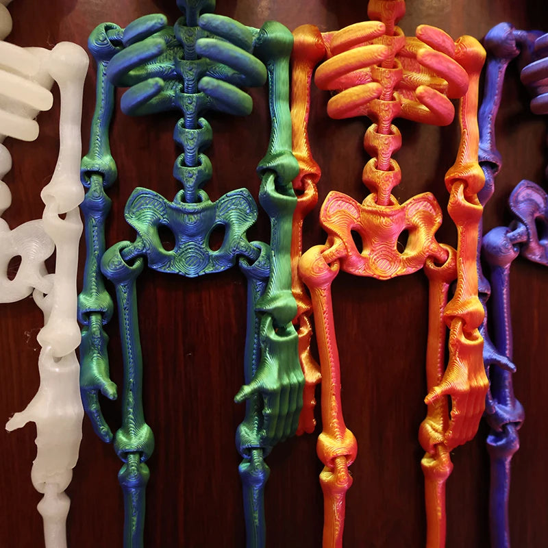 A display of poseable luminous skull fridge magnets in white, teal, and orange colors.
