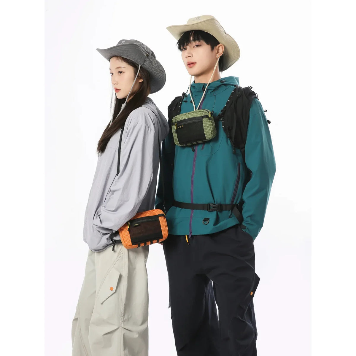 A young man and woman wearing outdoor tactical clothing and a waterproof waist bag.