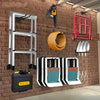 A wall-mounted organizer rack for garden tools, featuring a silver and black frame, mounted on a brick wall.