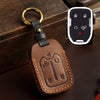 Brown leather key fob case with a brass ring attached, featuring cutouts for Chevrolet and GMC keys.