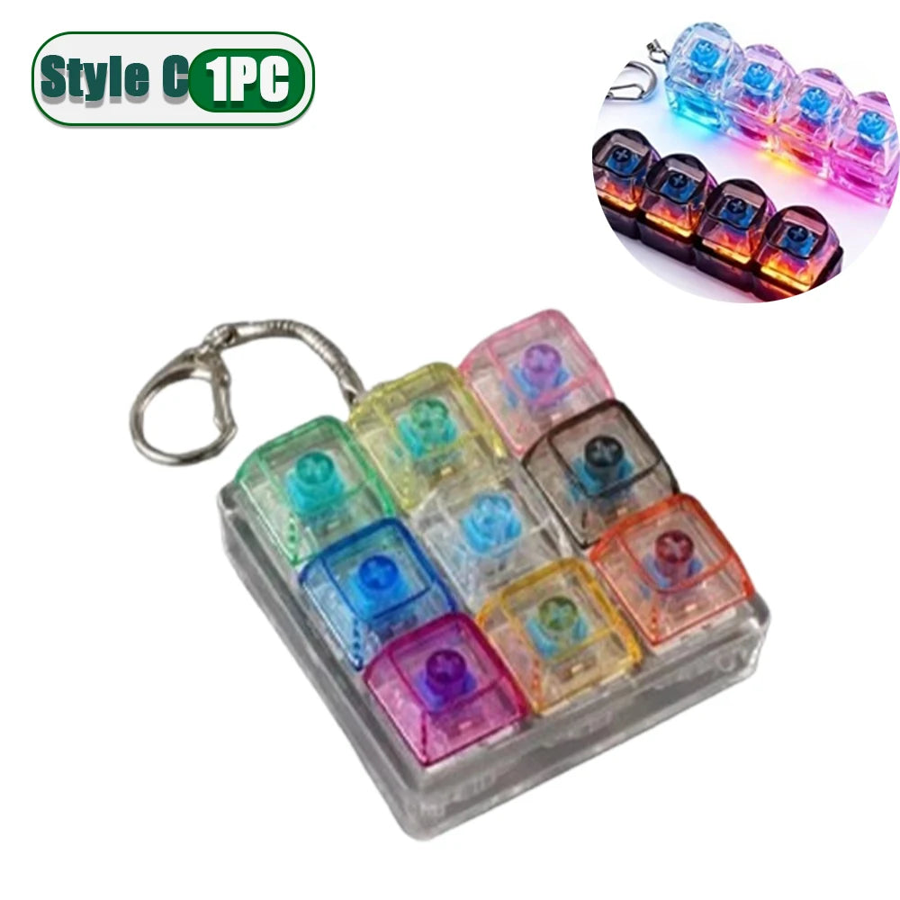 A clear plastic fidget keychain featuring multiple colorful LED lights arranged in a keyboard design.
