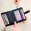 A black bi-fold credit card wallet with a gold chain detail is shown being held by hands.